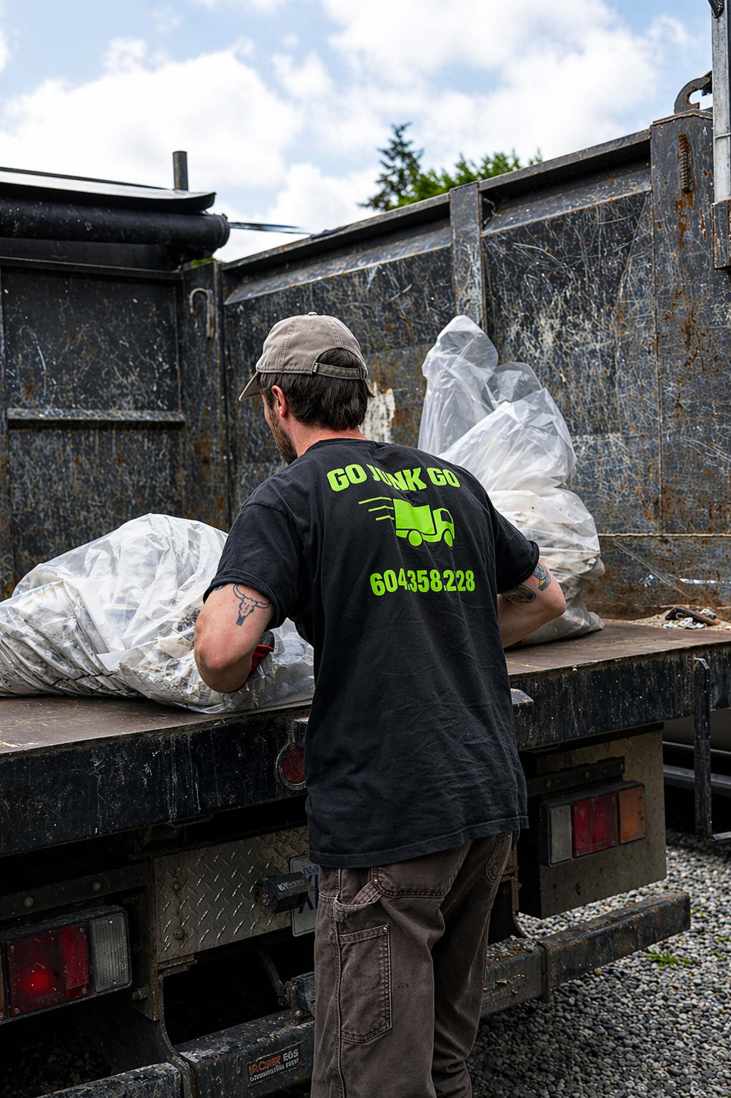 Go Junk Go crew member loading bagged drywall debris onto the truck bed during a Vancouver renovation cleanup